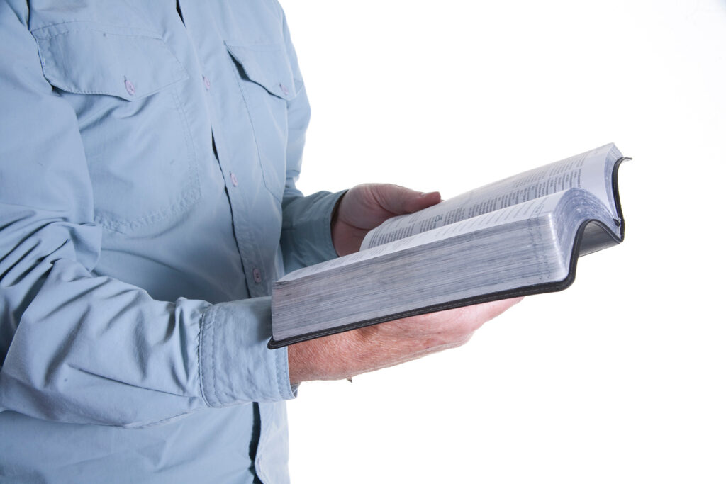 man praying holding a Bible